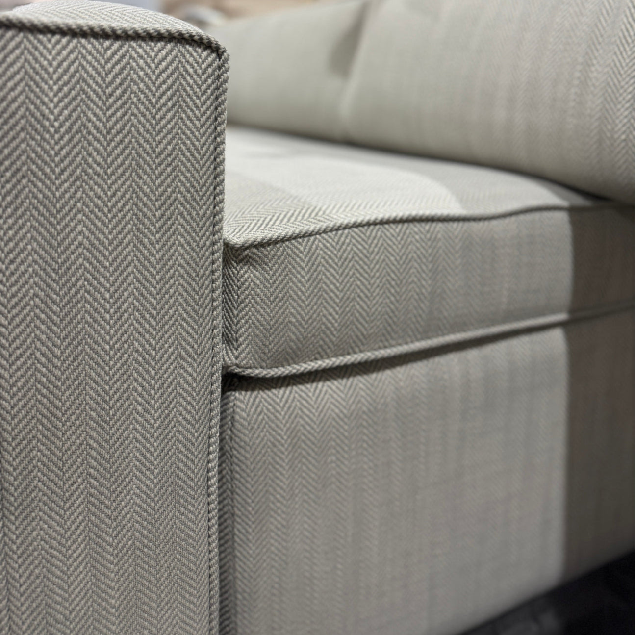 Gray sofa with a herringbone pattern in a warehouse setting