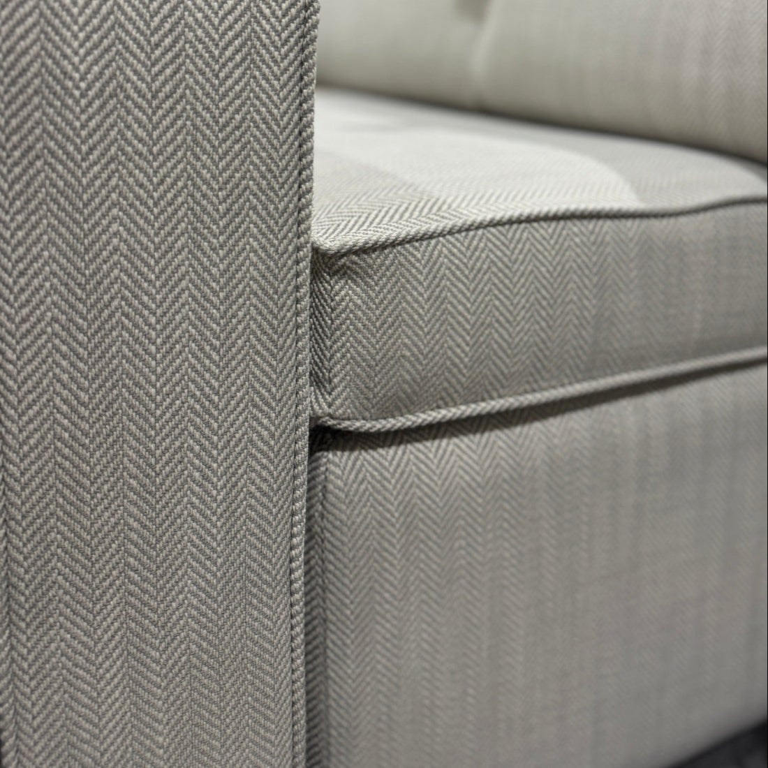 Gray sofa with a herringbone pattern in a warehouse setting