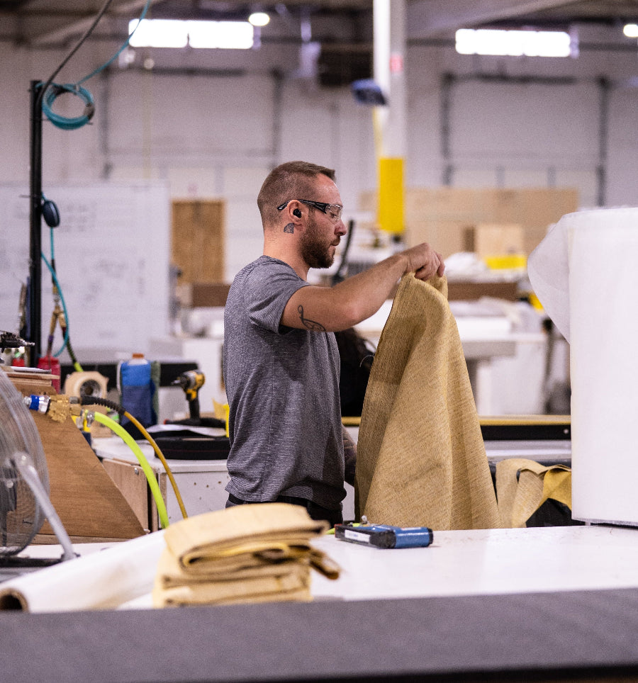 Man working with fabric in a warehouse setting