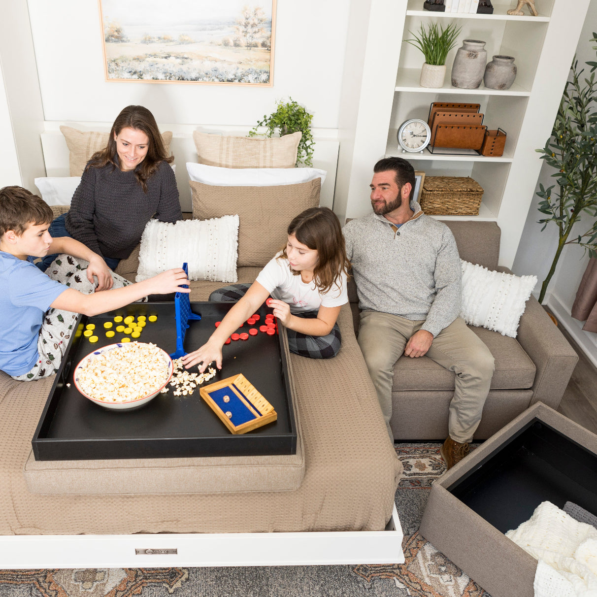 Family playing a board game together in a living room.