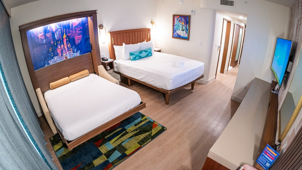 Murphy bed at Disney, Inovabed-- bedroom with two beds, a television, and a colorful rug.