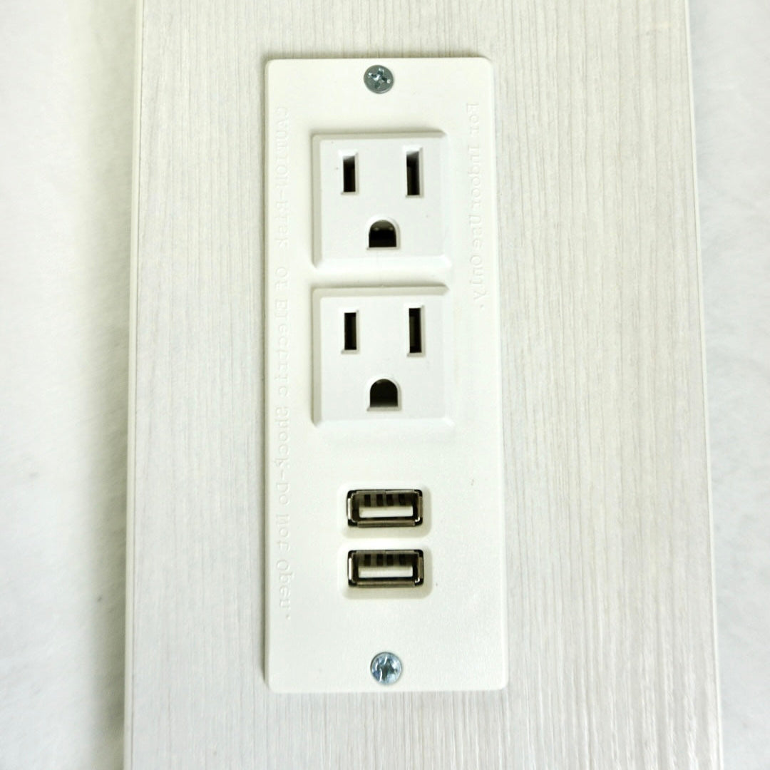 Wall outlet with multiple sockets and USB ports on a textured white background