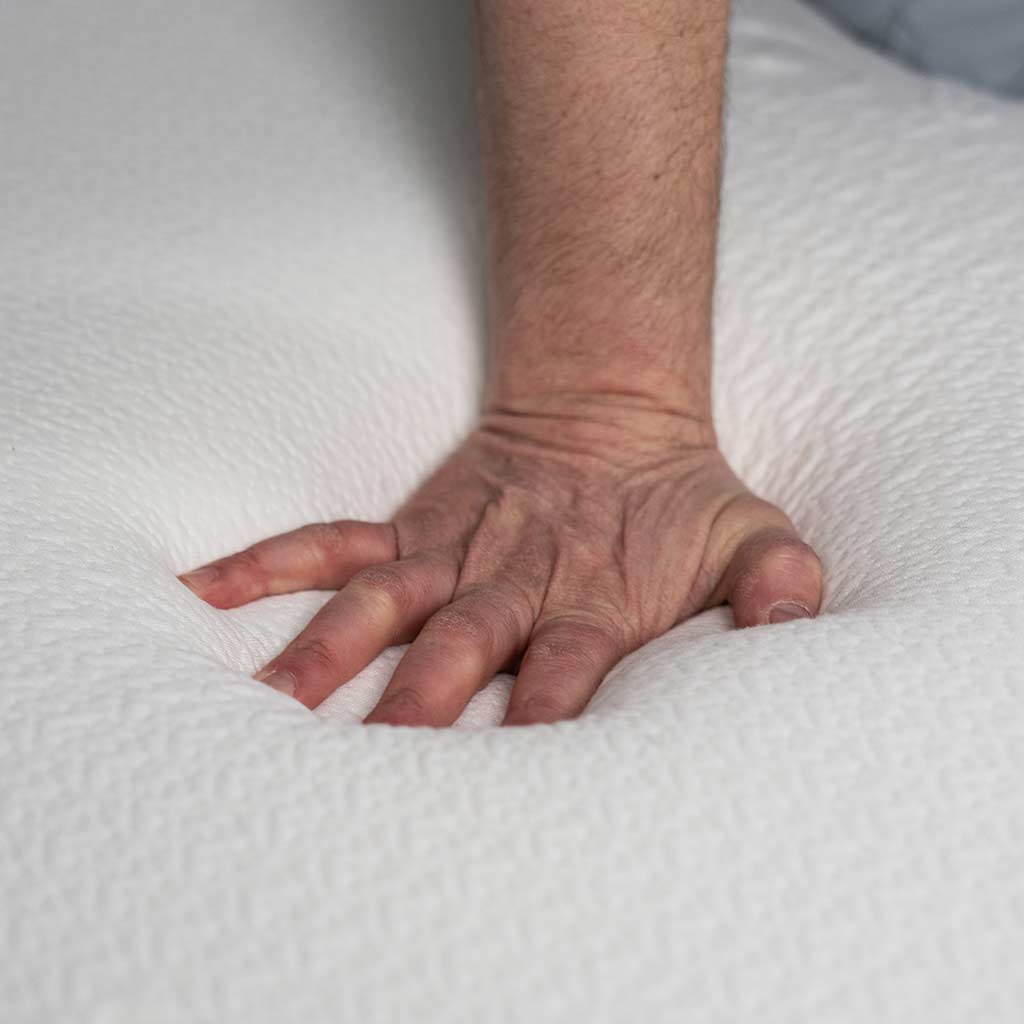 masculine hand pressing into Polysleep 10" mattress showing it's comfort