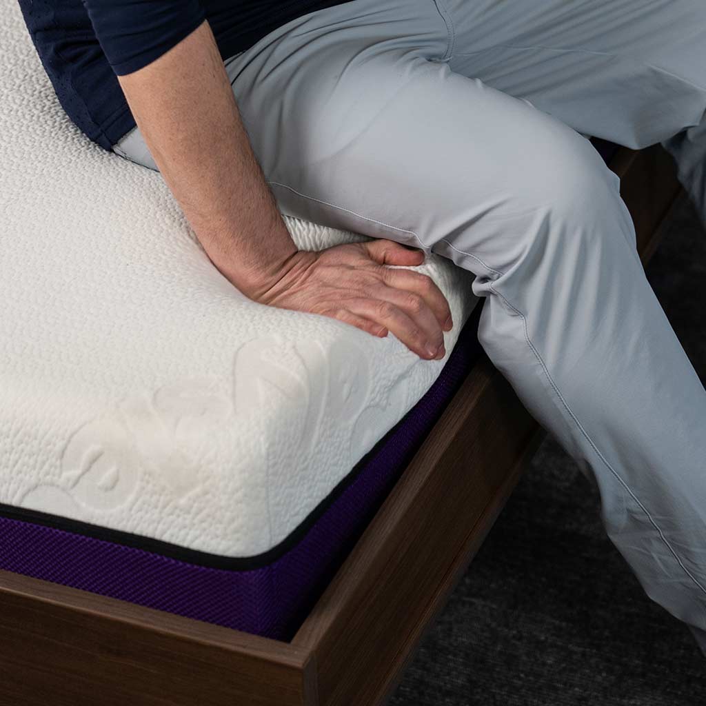 Man sitting on edge of wall bed on top of Polysleep 10" mattress