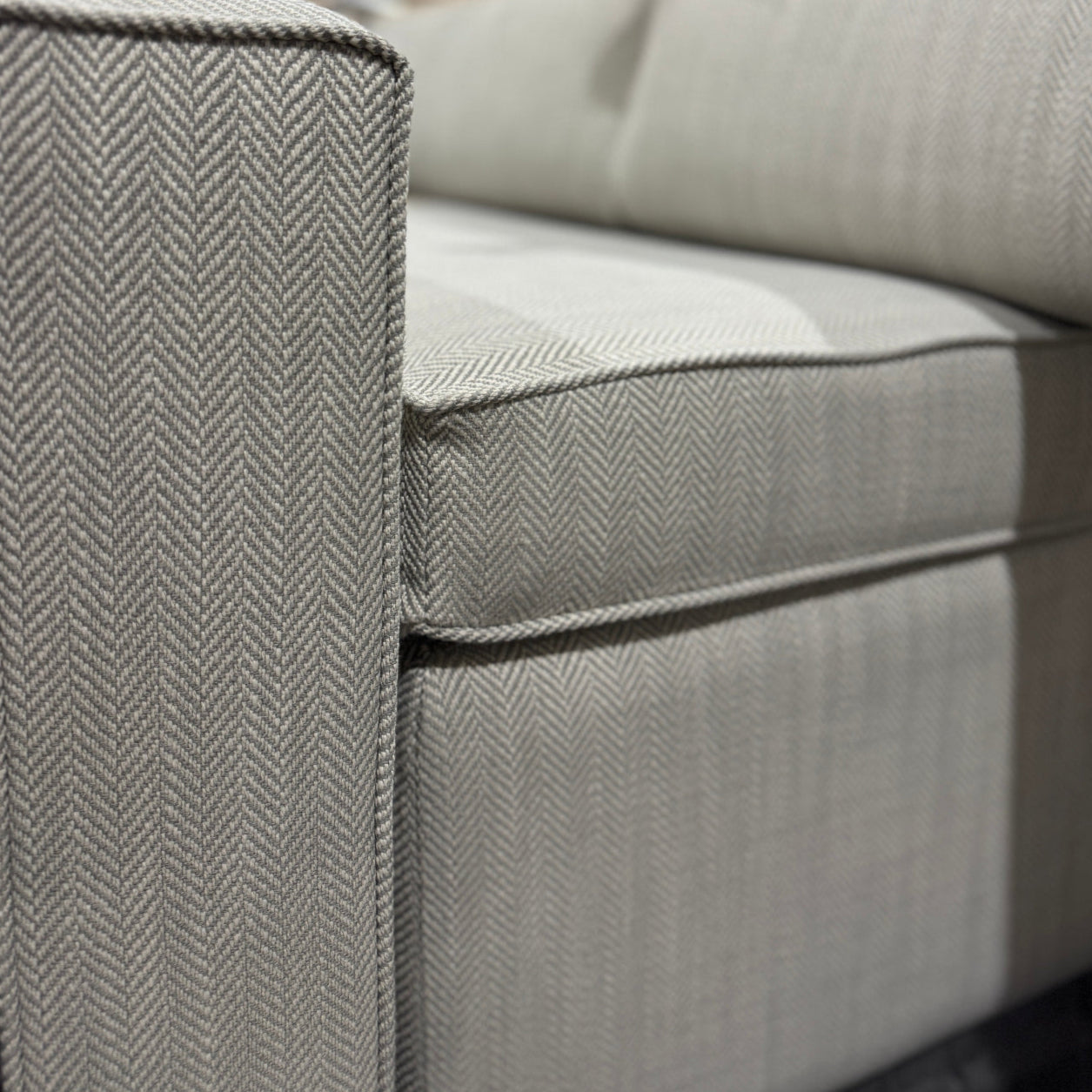 Gray sofa with a herringbone pattern in a warehouse setting