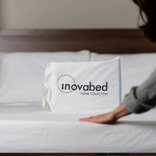 Woman's hand flattening Inovabed Home Collection - Queen Sheet Set on modern wall bed.