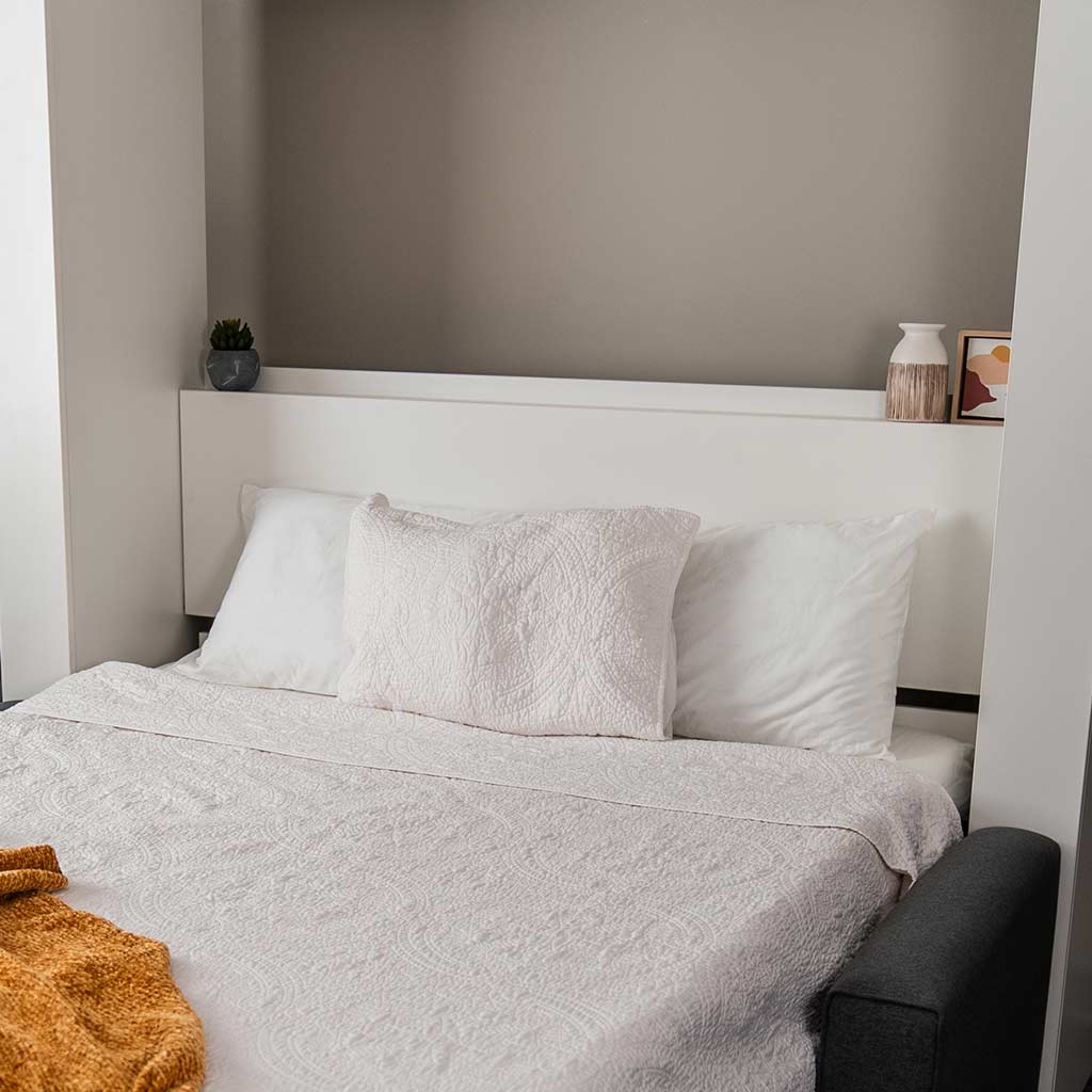 Detail shot of the Wall Bed with Sofa open to visually see the headboard that unlatches.